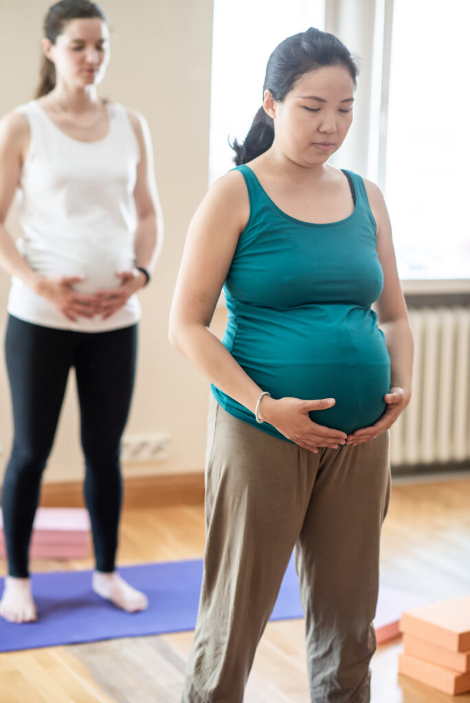 Pregnant ladies at yoga class relaxed and calm